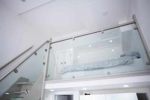 uma escada de vidro com uma cama em Quirky, Stylish & Modern Studio in Central Reading em Londres
