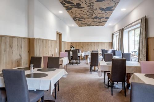 a dining room with white tables and chairs at Hotel Zum Gourmet in Seefeld in Tirol