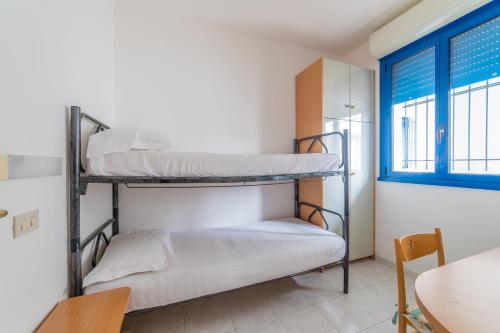 a room with two bunk beds and a table at Residence Il Sole in Porto Corsini