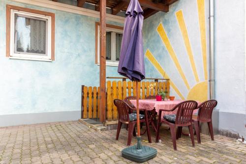 a table with chairs and an umbrella in a patio at apartment fewo efosa in Kappel-Grafenhausen