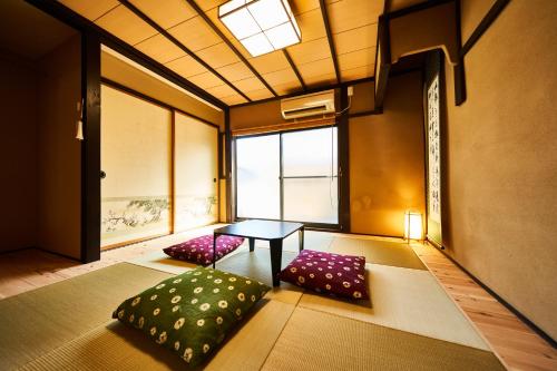 een kamer met 2 kussens en een tafel met een raam bij Yadoya Jin in Kyoto