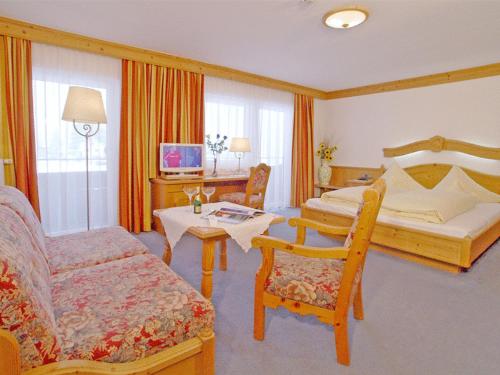 a hotel room with a bed and a table and chairs at Hotel Hagerhof in Thiersee