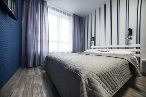 a bedroom with a bed with blue walls and a window at Solo Apartment Kamenskaya in Kyiv