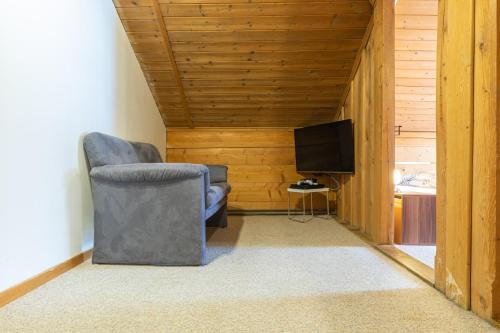 a living room with a chair and a television at Chalet Weid - Aare Jungfrau AG in Grindelwald