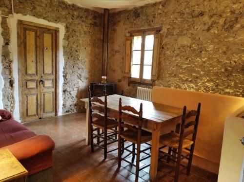 a dining room with a wooden table and chairs at Ca la iaia Veva in Sant Joan les Fonts