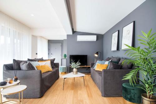 a living room with two couches and a tv at Nôma Living Pop Saldanha in Lisbon