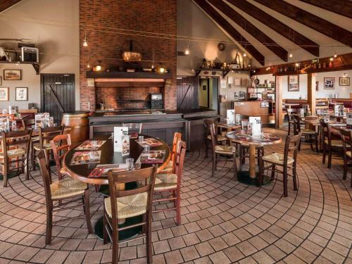 une salle à manger avec des tables et des chaises dans un restaurant dans l'établissement ibis Saint Dizier, à Saint-Dizier