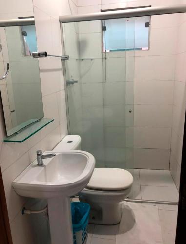 a bathroom with a toilet and a sink and a shower at Mais Hotel in Araguaína