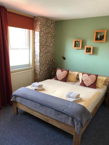 a bedroom with a large bed with towels on it at Pension Mühlhahn in Schierke