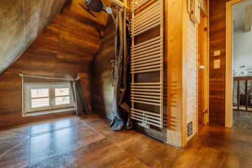 an attic room with wood floors and a window at Haus Anna Elbe, Bauernhaus-Ferienwohnungen an der Elbe in Hamburg