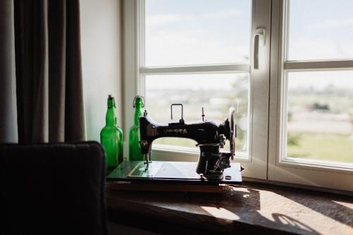 a sewing machine sitting on a table next to a window at Haus Anna Elbe, Bauernhaus-Ferienwohnungen an der Elbe in Hamburg