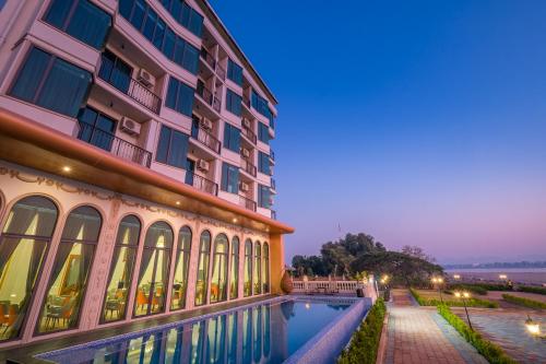 a hotel with a swimming pool in front of a building at Mekong Heritage Hotel in Nakhon Phanom