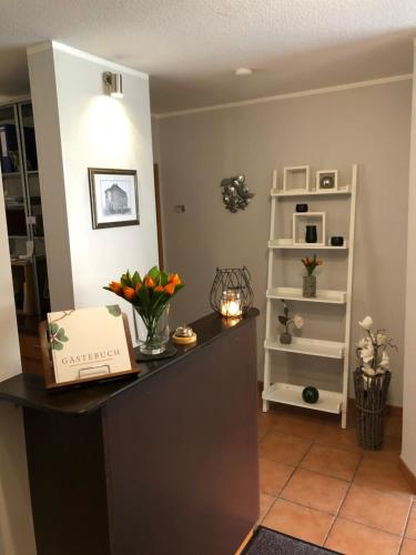 a room with a counter with flowers and a shelf at Pension Mühlhahn in Schierke