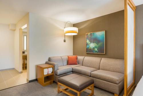 a living room with a couch and a table at Hyatt Place Hampton Convention Center in Hampton