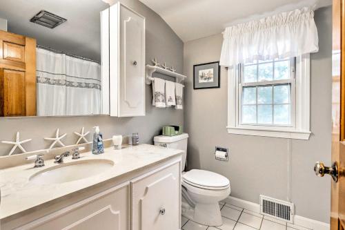 a bathroom with a toilet and a sink and a window at 2 Mi to Shore Home with BBQ and Beach Gear in Mashpee in Mashpee