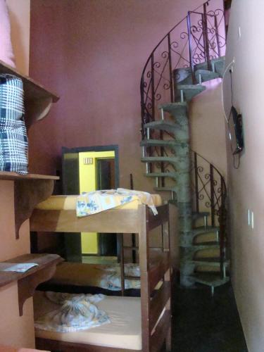 a room with a spiral staircase in a room at Pousada Y-Goá in Bertioga
