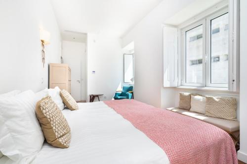 sypialnia z dużym białym łóżkiem i różowym kocem w obiekcie Chalet Estoril Luxury perfect for Families & Friends w mieście Estoril
