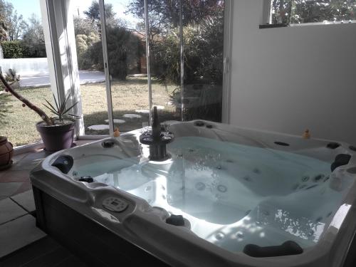una vasca da bagno in una stanza con finestra di L'eden naturiste spas a Challans