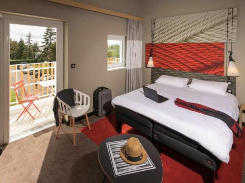 Habitación de hotel con cama y balcón en ibis Nantes Saint Herblain en Saint-Herblain
