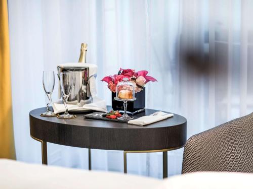 a table with a blender and wine glasses on it at Century Old Town Prague - MGallery Collection in Prague