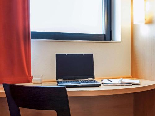a laptop computer sitting on top of a desk at Ibis Ripollet in Ripollet