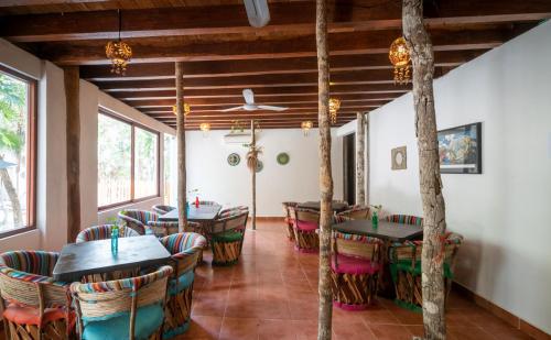 a restaurant with tables and chairs in a room at Ecovergel Hotel Riviera Maya in Chemuyil