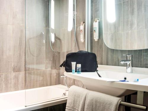 ラ・クールヌーヴにあるibis Paris Le Bourgetのバスルーム(洗面台、トイレ、シャワー付)