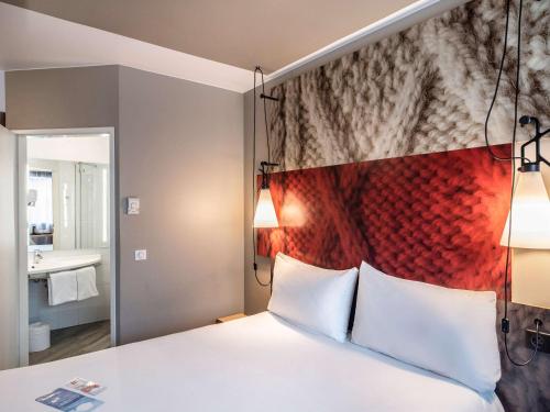 een slaapkamer met een groot bed met een rood hoofdeinde bij Hotel Ibis Krakow Centrum in Krakau