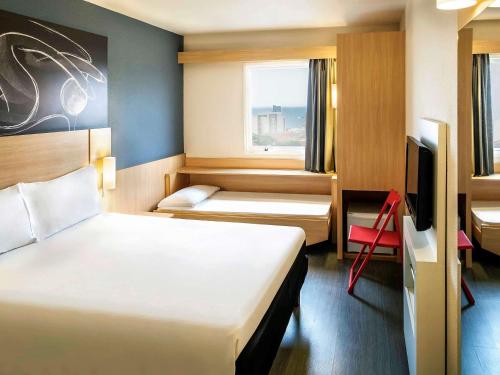 Habitación de hotel con 2 camas y TV en ibis Macae, en Macaé