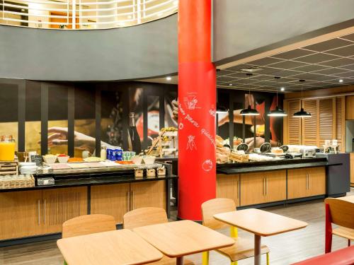 a restaurant with tables and a buffet of food at ibis Campinas in Campinas