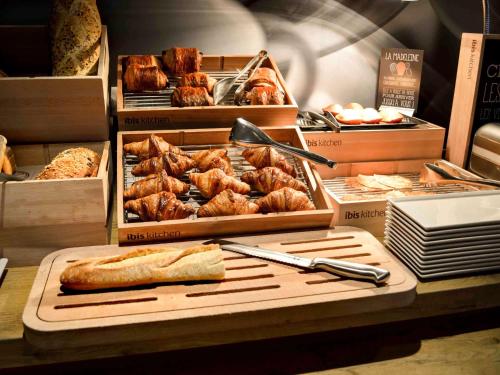 a display of bread and pastries in boxes on a table at ibis Honfleur in Honfleur