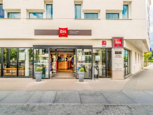 a store front of a building with a ups store at ibis Marne La Vallée Val d'Europe in Montévrain