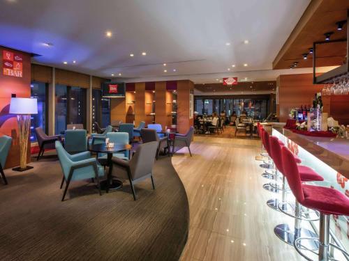a restaurant with chairs and tables and a bar at Ibis Ambassador Myeongdong in Seoul