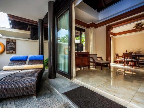 a living room with a couch and a dining room at Pullman Sanya Yalong Bay Villas & Resort in Sanya