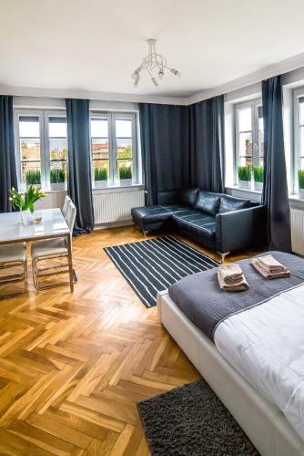 a living room with a bed and a couch and a table at Cracovia Apartments in Krakow