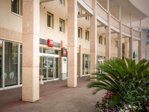 an empty lobby of a building with plants and flowers at ibis Martigues Centre in Martigues