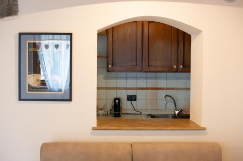 een keuken met een wastafel en houten kasten bij StudiÒ Aubert in Aosta