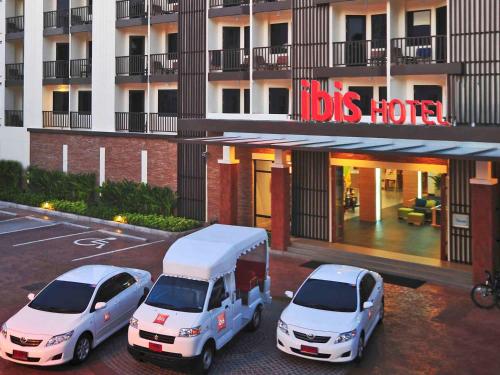 three cars parked in a parking lot in front of a hotel at Ibis Phuket Kata in Kata Beach