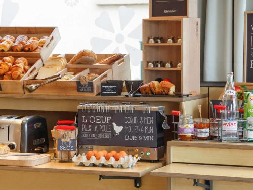 a bakery with a counter with pastries and donuts on it at ibis Etampes in Étampes