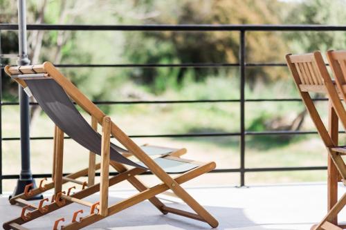 two wooden chairs sitting on a balcony at Villa du Macchione BASTIA by Location-tourisme-corse in Bastia