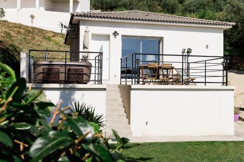 a white house with a grill and a table at Villa du Macchione BASTIA by Location-tourisme-corse in Bastia