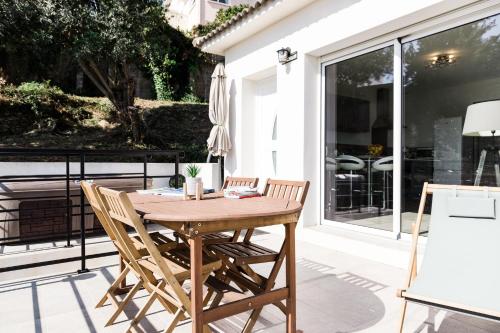 a wooden table and chairs on a patio at Villa du Macchione BASTIA by Location-tourisme-corse in Bastia