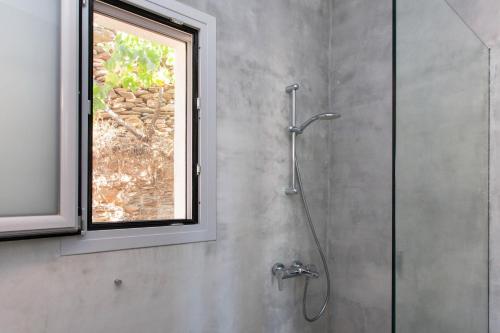 a shower in a bathroom with a window at Kea Villa Thea- Villa Ilios in Vourkarion