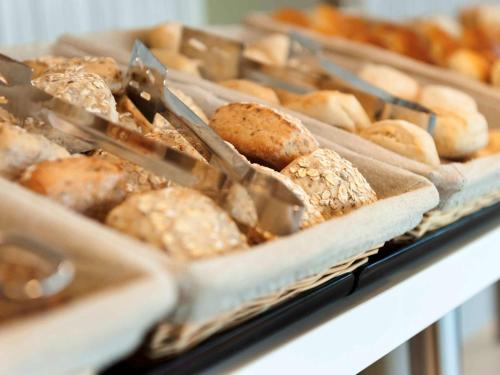 a bunch of different types of pastries on a shelf at ibis Budget Brussels South Ruisbroek in Ruisbroek
