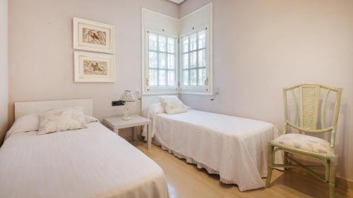 カラフェルにあるR60 Casa Sendoのベッドルーム1室(ベッド2台、椅子、窓付)
