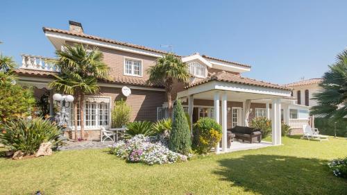 a house with a porch and a lawn at R60 Casa Sendo in Calafell