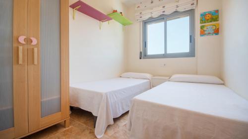カラフェルにあるR34 Ático RAMBLAのベッド2台と窓が備わる客室です。