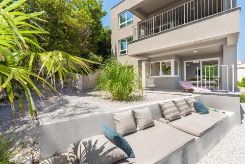 a couch sitting in front of a house at House 61 Sveta Marina in Sveta Marina
