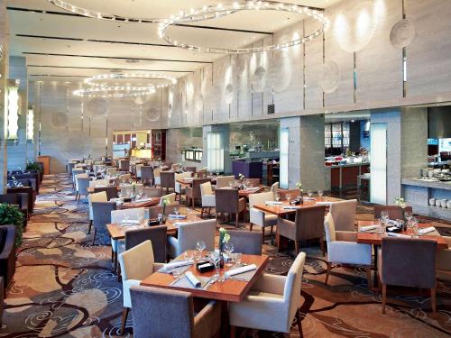 a dining room with tables and chairs in a restaurant at Pullman Xiamen Powerlong in Xiamen