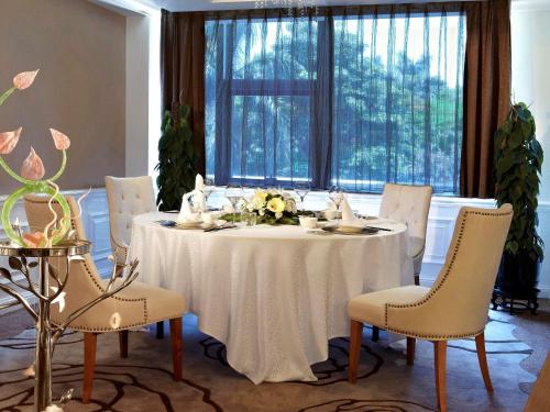 a table with a white table cloth and chairs at Pullman Xiamen Powerlong in Xiamen